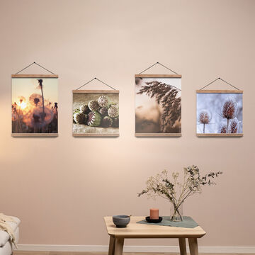 Quattro poster con foto di piante e fiori appesi alla parete tramite supporto in legno